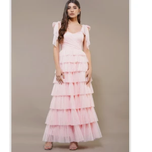 Ljusrosa långklänning med volanger från Lace & Beads - Säljer en ljusrosa långklänning från Lace & beads. Justerbara axelband. Perfekt för bal eller fest. Modellen heter Ophelia Maxi Dress. Helt ny aldrig använd. Helt slutsåld på ASOS. Pris går att diskutera❤️