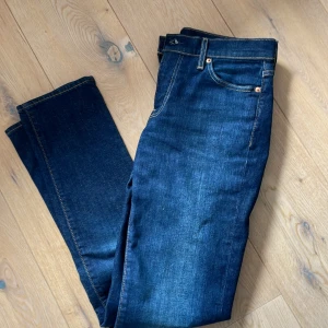 Levi's 511 blå jeans - Säljer ett par klassiska blå Levi's 511 jeans med normal passform och raka ben. Jeansen har fem fickor, gylf med dragkedja och tydliga kontrastsömmar. Perfekta för en stilren vardagslook.