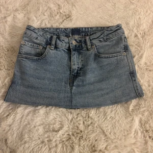 Blå jeanskjol med fickor - Säljer en klassisk blå jeanskjol med fem fickor och bälteshällor. Kjolen har knapp- och dragkedjestängning framtill samt två bakfickor med lock och knapp. Perfekt för en avslappnad och trendig look. Omsyd själv från byxor till kjol🥰. Priset går att diskutera !!! Skulle uppskatta kjolen som storlek xs