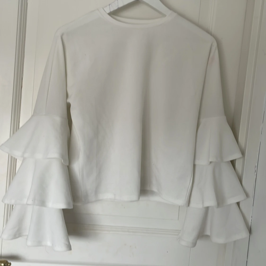 Vit långärmad topp med volangärmar