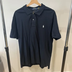 Ralph Lauren piké tröja - Helt ny och oanvänd Ralph Lauren pike tröja, 10/10 skick. Lite skrynklig bara pga en flytt, Men de går bort fort. Det är storlek XL men jag tycker den sitter som en L. Riktigt snygg och bekväm. Perfekt till sommaren. Rekommenderar starkt!