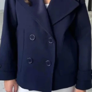 Design by si kappa  - Säljer en klassisk mörkblå skepparkavaj med dubbelknäppning och bred krage. Jackan har långa ärmar och en stilren design som passar perfekt till många outfits.