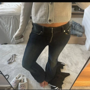 Bootcut mörkblå jeans med låg midja - Snygga mörkblå bootcut jeans med låg midja och klassisk femficksdesign. Jeansen har en dragkedja framtill och är tillverkade i ett stretchigt denimtyg som sitter skönt och formar benen. Perfekta för dig som gillar en retro vibe och vill ha en cool siluett. Köpt på Vinted men ha inte använt dom själv