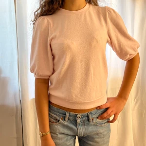 Ljusrosa topp med puffärm - Supersöt ljusrosa topp med puffiga tre kvarts ärmar. Skönt material, och passar alla klädsammanhang. Hör av er vid fler frågor eller funderingar!