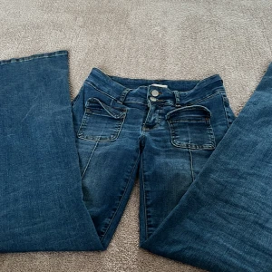 Blå bootcut jeans från Nelly - Säljer ett par utsvängda jeans från Nelly! Använda en gång, syns ingenting att de är använda! Köpte för 500. 