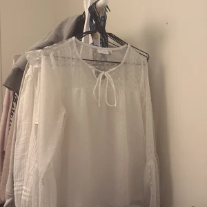 Vit blus från Vila - Supersöt vit blus från Vila med diskret prickigt mönster. Blusen är endast använd ett fåtal gånger därmed i väldigt fint skick🥰