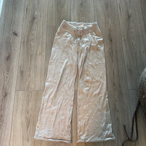Beige mjukisbyxor från Gina Tricot - Superbekväma beige mjukisbyxor som både är sköna och snygga från Gina Tricot med bred ribbad midja och snörning. Byxorna har raka, lite vidare ben och är gjorda i mjukt material som känns skönt mot huden. Perfekt för att vara lite chill men ändå snygg👍💕