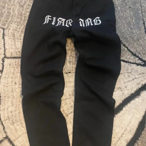 Svarta jeans med tryck från SHEIN - Svarta jeans från SHEIN med coolt vitt tryck över framsidan. Modellen har raka ben, klassiska bakfickor och hällor för bälte. Materialet är en mix av bomull och polyester som ger en skön känsla och bra passform. Perfekt för dig som gillar streetstyle.