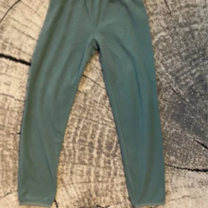 Gröna fleecebyxor från Everest - Mysiga gröna fleecebyxor från Everest i storlek 158/164. Byxorna har elastisk midja och är perfekta för chill eller utomhusaktiviteter när det är kallt. Mjukt material som känns skönt mot huden och enkel, stilren design.