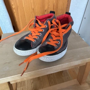 Converse - Ett par Converse i storlek 37 (EUR) i färgerna orange, grått och rött som har inte kommit särskilt mycket till användning pga. liten storlek. Färgglada och fräscha!