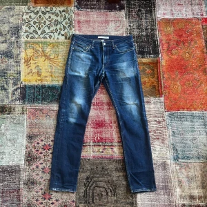 Calvin Klein Jeans - Snygga blå jeans från Calvin Klein med slim passform och klassisk femficksdesign. Jeansen har slitningar och en liten reva på framsidan för en cool, använd look. De har kontrastsömmar och Calvin Klein-logga på knappen. Perfekt för dig som gillar stilrena jeans med edge. Otroligt snygg tvätt och bra skick. Str 32/32. Pris 399.   Hör av dig vid minsta fundering!