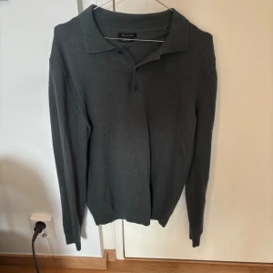  Massimo Dutti - Snygg mörkgrön stickad pikétröja från Massimo Dutti med klassisk krage och tre knappar framtill. Tröjan har långärmad passform och är gjord i mjukt material som känns skönt mot huden. Perfekt för dig som gillar stilrena och enkla plagg.        Storlek medium men sitter som en small.