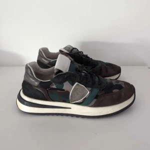 Philippe Model Camo trainers - Säljer ett par unika feta skor från Philippe Model. Skorna är i en sjukt populär Camo färg och är i väldigt bra skick. De sitter i strl 41-42 och hör gärna av er vid frågor eller funderingar!!