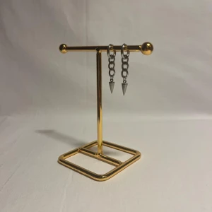 Silvriga kedjeörhängen med spikes - Säljer ett par coola örhängen i silverfärgad metall med kedjor och spetsiga spikes som hänger längst ner. Perfekt för dig som gillar edgy och stilrena detaljer. Örhängena har en modern vibe och passar till streetwear eller rockig stil.
