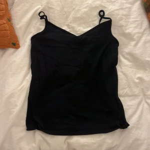 Svart linnetopp från Cubus - Enkel svart linnetopp från Cubus med smala axelband och v-ringad hals. 