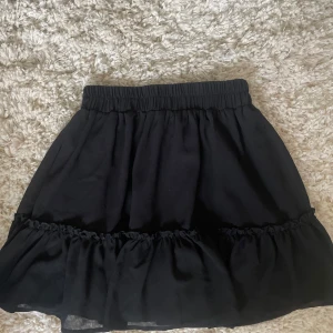 Svart volangkjol med resårmidja - Supersöt svart volangkjol!