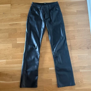 Svarta skinnbyxor BikBok - Snygga svarta skinnbyxor från BikBok i rak modell. Byxorna har klassisk femficksdesign, bälteshällor (en är lös men kan sys fast) och stängs med knapp och dragkedja. De är pyttelite slitna längst ner men inget man märker🖤