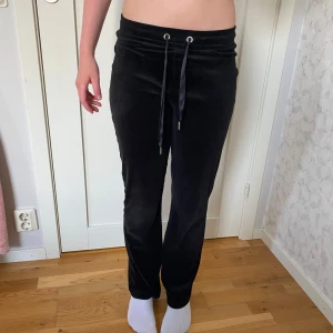 Svarta mjukisbyxor från Gina Tricot - Svarta mjukisbyxor från Gina Tricot i storlek XS. Byxorna har en mjuk och skön känsla med snörning i midjan och raka ben. Perfekta för chill dagar eller när du vill vara extra bekväm. Materialet är lent och har en snygg, enkel look.