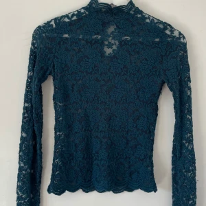 Spets topp  - Långa ärmar och fina vågiga kanter. Baksidan har en liten öppning med tre knappar vid nacken. Perfekt för dig som gillar detaljer. Knappt använd 