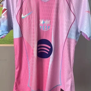 Barcelona Lamine Yamal rosa matchtröja - Snygg Barcelona fotbollströja med Lamine Yamal och nummer 10 på ryggen. Tröjan är rosa med ljusblå detaljer och har ett grafiskt mönster framtill. Nike-logga och Spotify-sponsor på bröstet. Kortärmad och tillverkad i lätt, ventilerande material.