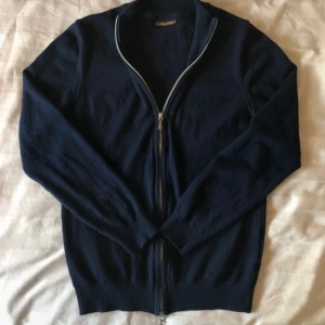Stenströms full zip tröja - Stilren marinblå merinoull tröja från stenströms. Perfekt för alla tillfällen. Inga defekter alls, förutom att det har krympt lite i tvätten. Storleken är S men skulle säga att den passar runt 165-172. Ställ gärna mer frågor! Nypris: 2300kr