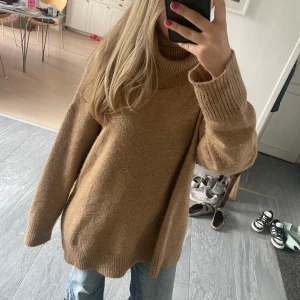 Oversized brun beige polotröja stickad - -Mysig oversized polotröja i en varm brun färg med guldtrådar.                                                 -Stickad med grov ribbad krage och muddar vid ärmslut och nederkant. Lång ärm och loose fit.                                 -Perfekt för lager-på-lager och chill dagar.🩷