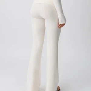 Vita bootcut byxor med hög midja - Snygga vita bootcut byxor med hög midja och lång benlängd. De har en mjuk och stretchig passform som sitter skönt och följer kroppen. Perfekta att styla med sneakers eller sandaler för en clean look.