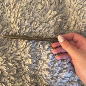 Delilah brun ögonbrynspenna Twig - Slimmad och vegansk ögonbrynspenna från Delilah i färgen Twig, en naturligt brun nyans. Pennan har en smal spets för exakt applicering och är fri från parabener. Perfekt för att forma och fylla i brynen med ett mjukt och naturligt resultat.