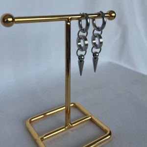 Silvriga örhängen med kedjor och spikes - Ett par coola silvriga örhängen med ringar, kedjor och spetsiga spikes längst ner. De har en edgy vibe och passar perfekt för dig som gillar statement-smycken. Metallisk finish och modern design gör dem till ett riktigt blickfång.