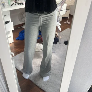 Grå mjukisbyxor med snörning - Säljer ett par grå mjukisbyxor med snörning framtill. Byxorna har en loose passform med raka, vida ben och är tillverkade i mjukt bomullsmaterial. De är mid waist. 