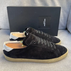 Svarta mocka sneakers från Saint Laurent - Hej! Säljer nu dessa sjukt snygga ysl skor. Skorna är i fint skick! Vi rekommenderar att gå ner en storlek. Har ett begränsat antal boxar och dustbag! Hör gärna av dig vid frågor 
