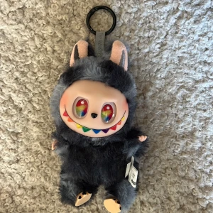 Pop Mart nyckelringsväska - Unik nyckelringsväska från Pop Mart. Den är köpt utomlands i frankrike så jag antar att det är en lafufu. Det är en secret som är mörkblå med fluffig päls. Den kommer med box men den har inget kort som bevisar att den är äkta. Lafufun kan vrida sitt huvud och har samma funktion som en labubu. Jag säljer den för jag har inte användning till den💗💗💗 Ni får gärna komma med förslag på priset!!!!