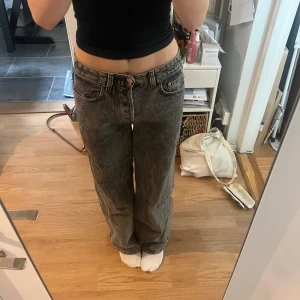 Grå wide jeans med hög midja - Hejjjjj, Jag säljer ett par gråa jeans med snygg tvätt och breda ben. Modellen har hög midja och klassiska fem fickor. Jeansen har en loose passform och raka ben, vilket ger en chill och trendig vibe. Perfekt för dig som gillar streetstyle och vill ha bekväma jeans.