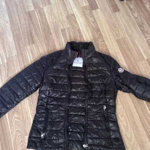 Svart Moncler pufferjacka - Säljer nu min moncler jacka som jag köpte här på plick men dom inte kommit till nån större användning, äldre modell, men passar perfekt som höst jacka!