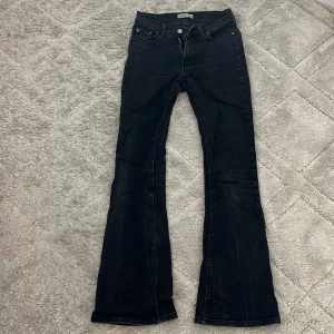Svarta bootcut jeans  - Snygga svarta jeans från gina Tricot, Perfect Jeans i storlek 34. Modellen har låg midja och bootcut-ben som ger en schysst siluett. Klassisk femficksdesign med knapp och dragkedja framtill. Materialet är jeans med lite stretch för skön passform.