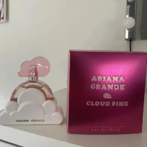 Ariana Grande Cloud Pink parfym - Superfin parfym från Ariana Grande, Cloud Pink. Flaskan har en unik design med rosa molnformad kork och står i en vit molnbas. Kommer i en glansig rosa kartong. Perfekt för dig som gillar söta och fräscha dofter.