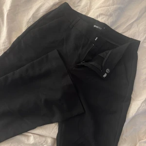 Svarta kostymbyxor från Gina Tricot - Snygga svarta kostymbyxor från Gina Tricot med rak passform och låg midja. Relaxed fit. 