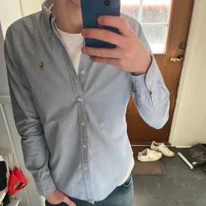 Ralph lauren skjorta  - Säljer en stilren ljusblå skjorta från Ralph Lauren i storlek S. Skjortan har långa ärmar och knappar framtill. Perfekt för en snygg och casual look. Köpt för ca 1200 men säljer för 449! Skicka meddelande vid frågor💭