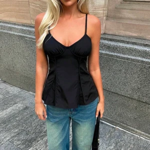 Svart korsettlinne - Säljer ett stilrent svart korsettlinne med smala axelband. Perfekt till sommarn och vintern och är i nyskick!💕