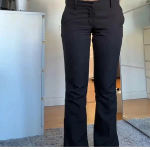 Svarta lågmidjade kostymbyxor 💕( lägger upp igen )  - Snygga svarta kostymbyxor med hög midja och bootcut-stil. Byxorna är i bra skick. Perfekta för en stilren look. Byxorna är lågmidjade med knappar och dragkedja framtill. ( lånad bild )