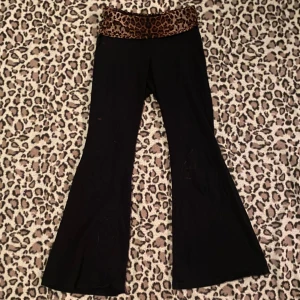 Svarta byxor med leopardmönstrad midja - Snygga svarta byxor med en leopardmönstrad låg midja. Byxorna har en bootcut-stil som ger en trendig look. Har några små blekningsfläckar.