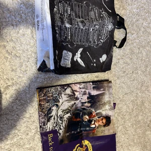 Harry Potter shoppingväska - Säljer en cool Harry Potter shoppingväska med Hogwarts-tema. Väskan har ett tryck av Hogwarts skollista och en bild av en trollkarl med trollstav. Perfekt för fans av magi och äventyr! 🧙‍♂️
