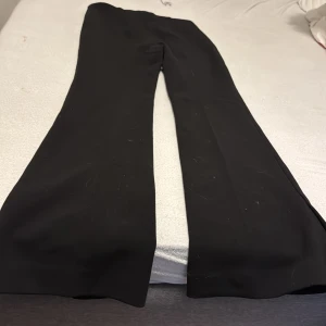 Svarta byxor från H&M - Snygga svarta byxor från H&M med en elegant bootcut-stil. Perfekta för en stilren look. Byxorna har en klassisk design som passar till många olika tillfällen.