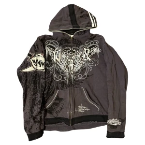 Svart zipup hoodie från WAX - Cool svart hoodie från WAX med tryck och text på både fram- och baksida. Den har en dragkedja framtill och en huva. Perfekt för en avslappnad stil. Jätte coolt print och distressed o unfinished hems vilket lägger till på designen av hoodien 🔥🔥