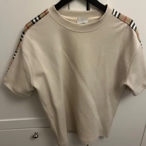 Beige t-shirt från Burberry - Säljer denna t-shirt från burberry pga för mycket kläder i garderoben! Använd fåtal gånger och är precis som ny skick, köpt från farfetch!