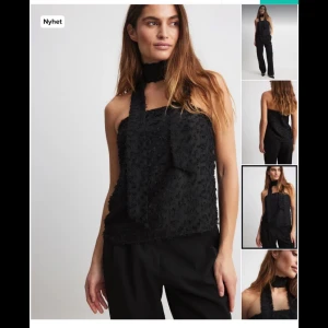 Svart ärmlös topp - Snygg svart ärmlös topp med en unik textur och halterneck-design. Perfekt för en stilren look. Strl är i S/xs skriv för mer information 