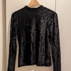 Svart sammetströja - Snygg svart tröja i mjukt sammetstyg med lite puffade axlar och långa ärmar.😊 Säljer då den är för liten för mig.