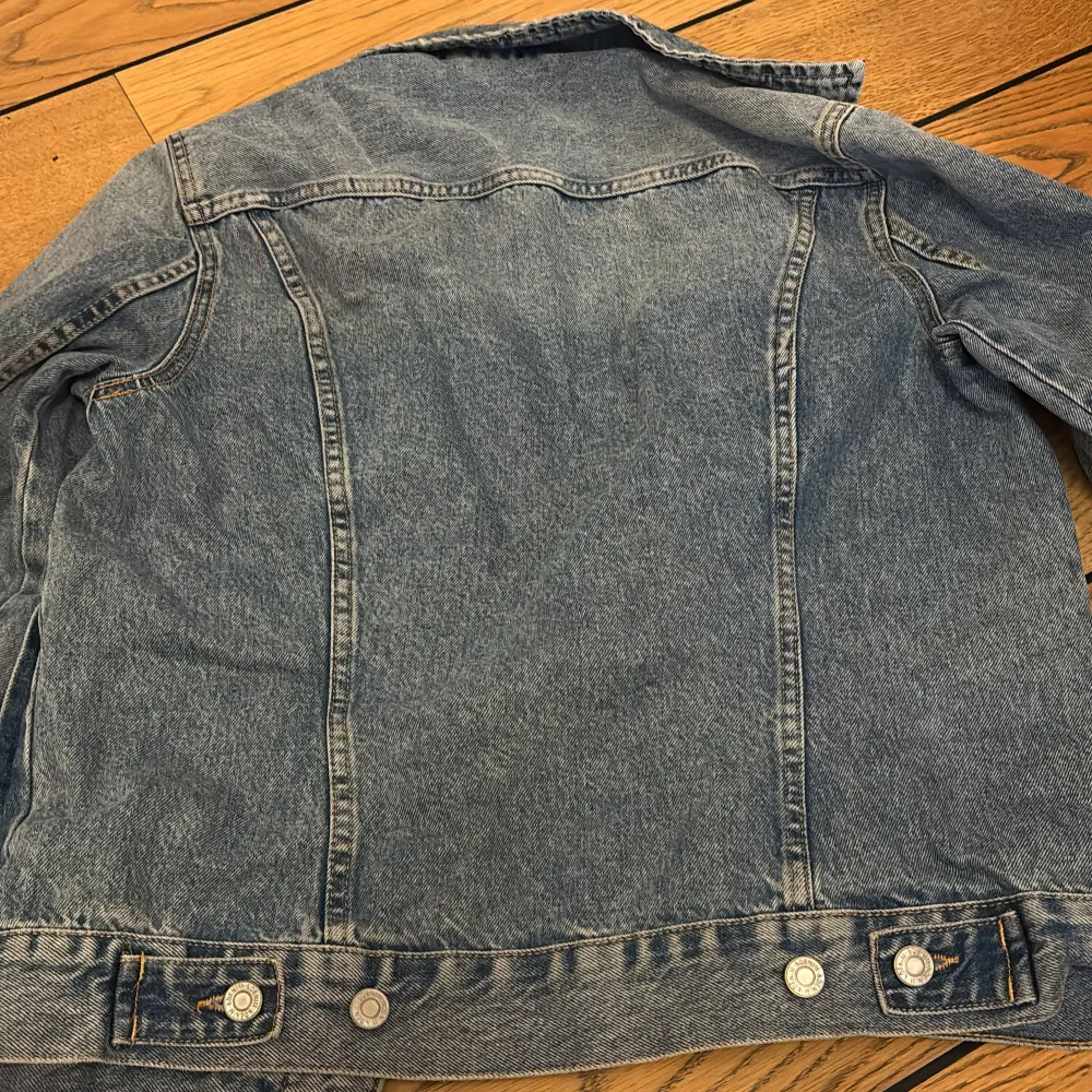 Säljer en klassisk blå jeansjacka från L.O.G.G. med knappar framtill och två bröstfickor. Jackan har en normal passform och långa ärmar. Perfekt för en avslappnad stil. 🧢👖. Takit.