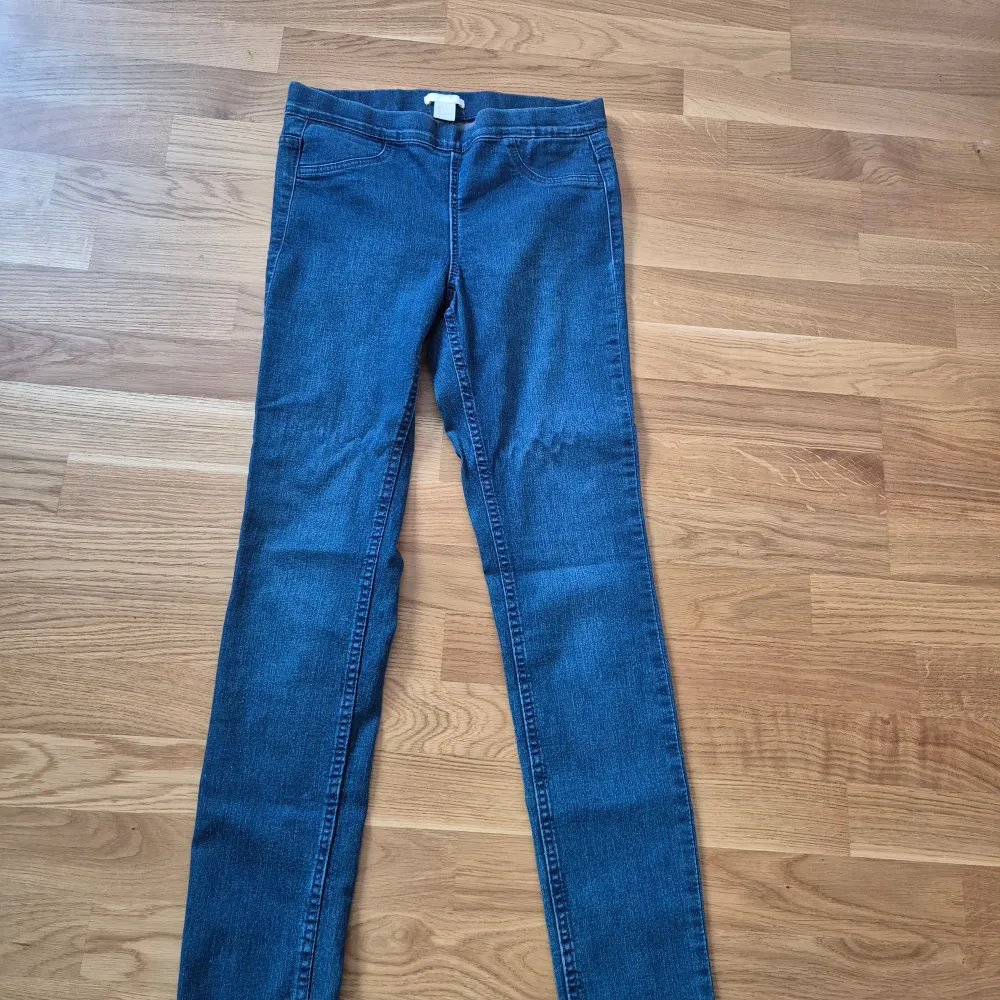 Snygga blå jeansbyxor med en klassisk design. De har en smal passform och är perfekta för en stilren look. Byxorna har fickor både fram och bak samt en dragkedja i gylfen.. Farkut & Housut.