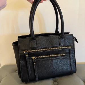 Svart handväska! - Älskar denna väska så mycket men får aldrig tillfälle för att använda den! Den är i väldigt fint skick. Köpt på Åhléns för längesedan. Väldigt rymlig. 270 kr!?! Så billigt!🥰😋